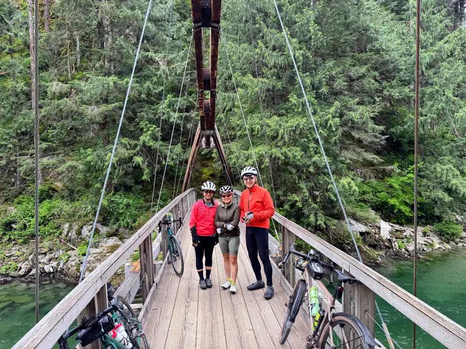 KREW riders with bikes on a suspension bridge in the forest